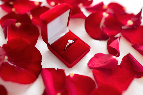 diamond ring in red velvet gift box on bed sheet - Фото, изображение
