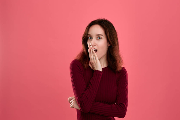 Sorpresa giovane donna in piedi isolato su sfondo rosa scuro con le mani alzate vicino alla bocca esprimendo emozione di shock
. - Foto, immagini