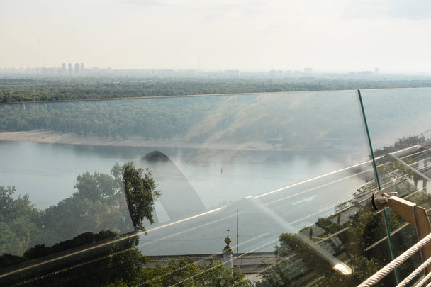 Kiev, junho de 2019 - Vista da margem esquerda de Dnipro a partir da nova ponte pedonal (Ponte Klychko) com arco de reflexão da amizade dos povos
 - Foto, Imagem