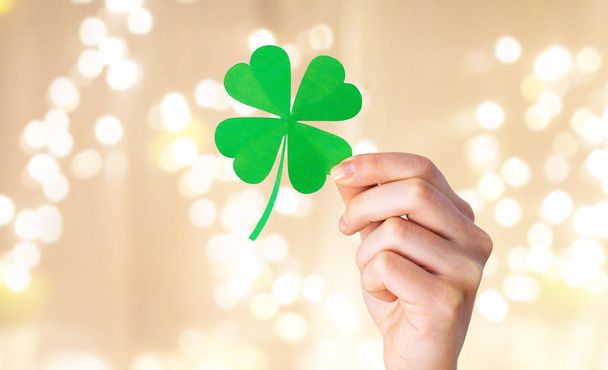 hand holding green paper four-leaf clover - Фото, изображение