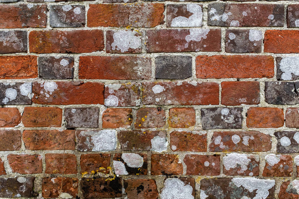 Feche uma parede de tijolo envelhecida com argamassa em ruínas e manchas brancas branqueadas
 - Foto, Imagem