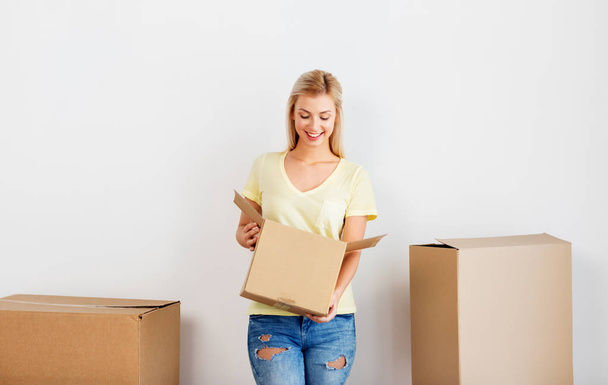 happy woman with cardboard box moving to new home - Zdjęcie, obraz