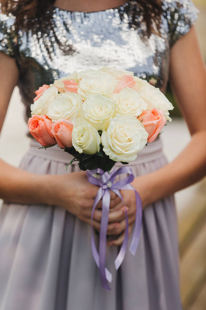 La novia en un vestido de novia elegante tiene un hermoso ramo de diferentes flores y hojas verdes. Tema de boda
 - Foto, Imagen