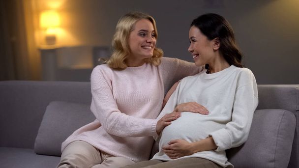 Excited woman touching tummy of her happy pregnant friend, maternity - Fotoğraf, Görsel