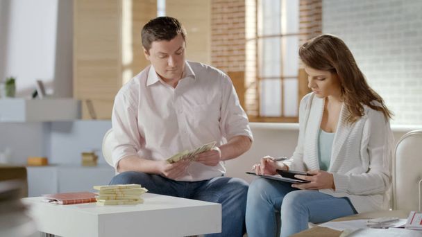 Rich married couple counting money, providing business together, family budget - Valokuva, kuva