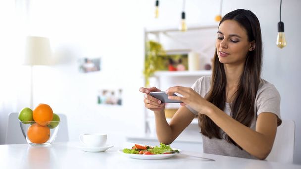 Nuori ruokabloggaaja tekee salaattikuvia puhelimessa, lähettämistä sosiaalisissa verkostoissa
 - Valokuva, kuva