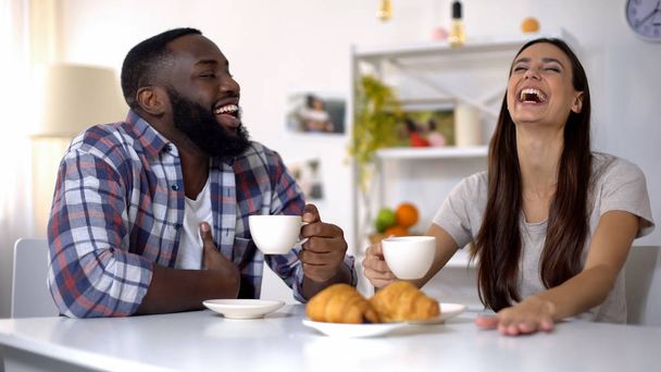 Multiethnic family joking and laughing during breakfast at home, morning coffee - Photo, image