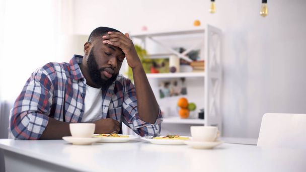 Tired African-American man having headache after hard day, feeling exhausted - Photo, image
