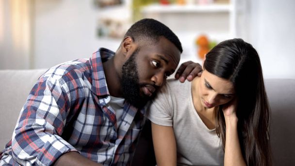 Black husband calming and supporting sad wife, health problems, miscarriage - Φωτογραφία, εικόνα