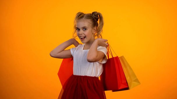 Cute little princess holding shopping bags, black friday sales, shopaholic - 写真・画像