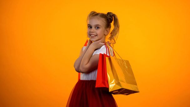Hermosa chica posando con bolsas de compras para cam, ventas y descuentos, plantilla
 - Foto, imagen