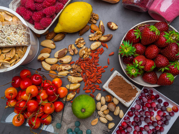 Sağlıklı gıda temiz yeme seçimi: tohumlar, superfoods, sebze ve meyve tozu gri beton arka plan üzerinde - Fotoğraf, Görsel