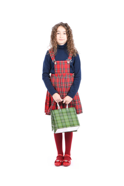 Child with a green packaging checkered texture isolated on white background. Girl likes shopping on sale season. Holiday present, shopping.  - Photo, Image