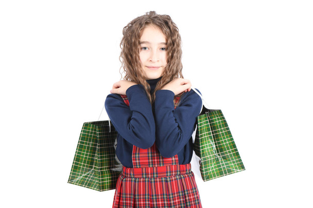 Child with a green packaging checkered texture isolated on white background. Girl likes shopping on sale season. Holiday present, shopping.  - Foto, Imagen