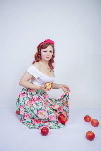 hübsche kaukasische junge Mädchen glücklich posiert mit roten Äpfeln. niedlichen Vintage-Dame im Retro-Kleid Spaß mit Früchten auf weißem Hintergrund allein. Vegetarierin liebt gutes Essen und Vitamine - Foto, Bild