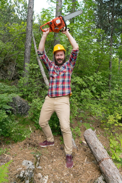 bearded lumberjack with a chainsaw makes faces - Foto, Imagem