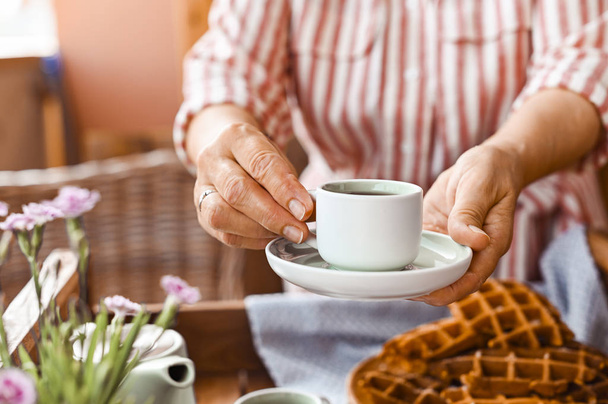Women holding a cup of tea. Homemade breakfast with waffles and  - Valokuva, kuva