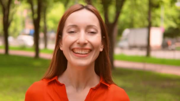 Κοκκινομάλλα γυναίκα χαμογελά ευρέως στη φύση το καλοκαίρι - Πλάνα, βίντεο
