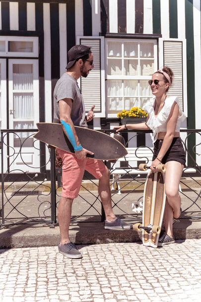 Young active couple enjoying a summer sunny day skateboarding - Fotoğraf, Görsel