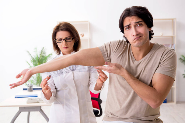 Médica verificando pacientes flexibilidade articular com goniômetro
 - Foto, Imagem