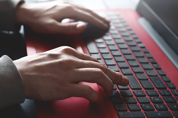 Вид сбоку, где человеческие руки заняты работой над ноутбуком, сидящим за деревянным столом. работа и учеба
 - Фото, изображение