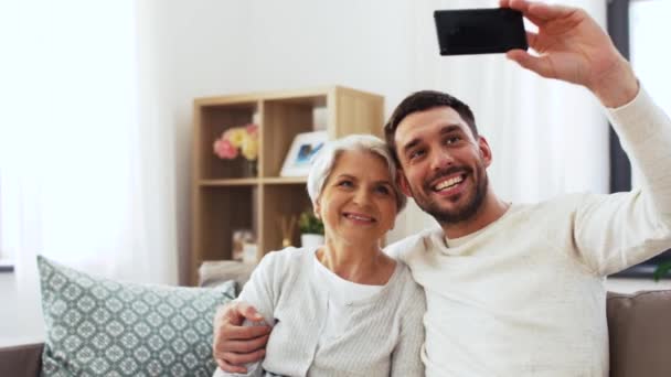 senior mother with adult son taking selfie at home - Metraje, vídeo