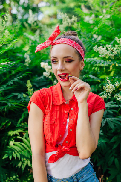 Beautiful young pin up girl with bright make up eating fresh natural strawberry. - Valokuva, kuva