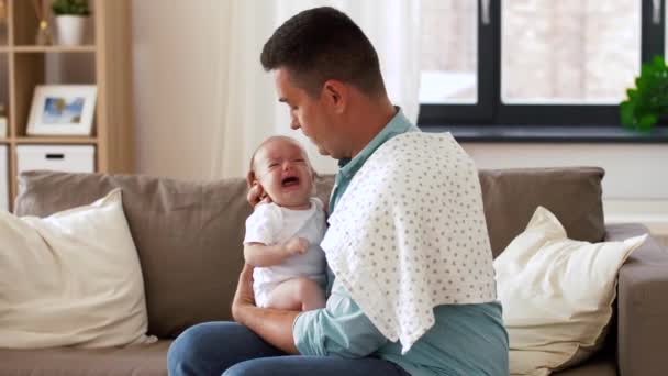 middle aged father with crying baby at home - Filmagem, Vídeo