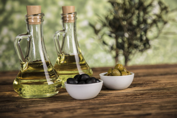 Olivový olej, olivovník, zelený a černý olivy na dřevěné tabuli - Fotografie, Obrázek