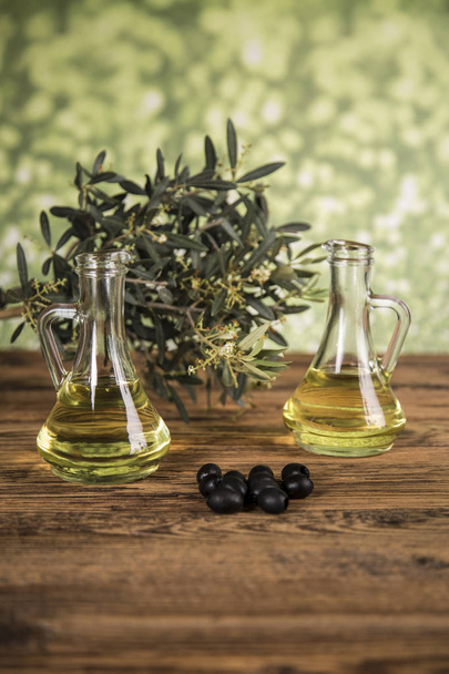 Olijfolie en olijfboom en zwarte olijven en flessen met olijf - Foto, afbeelding