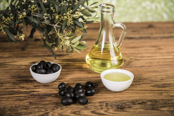 Оливковое масло и оливковое дерево, черные оливки и бутылки с оливковым маслом
 - Фото, изображение