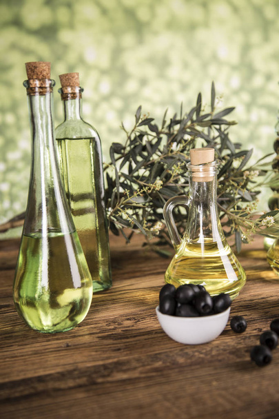 Azeite, oliveira e azeitonas verdes e pretas em uma aba de madeira
 - Foto, Imagem