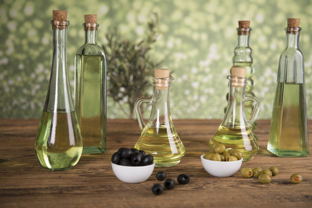 Olive oil, olive tree and green and black olives on a wooden tab - Fotoğraf, Görsel