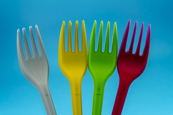 Fourchettes en plastique coloré sur fond bleu
 - Photo, image