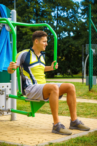Man flexing arm in outdoor gym - Fotó, kép