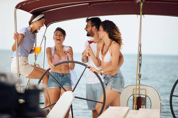Friends sitting on sailboat deck and having fun. Vacation, travel - 写真・画像