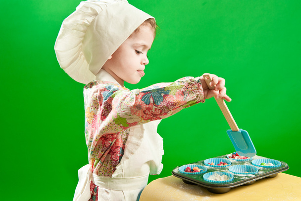 Small girl cooking in chef's hat and apron - Foto, imagen