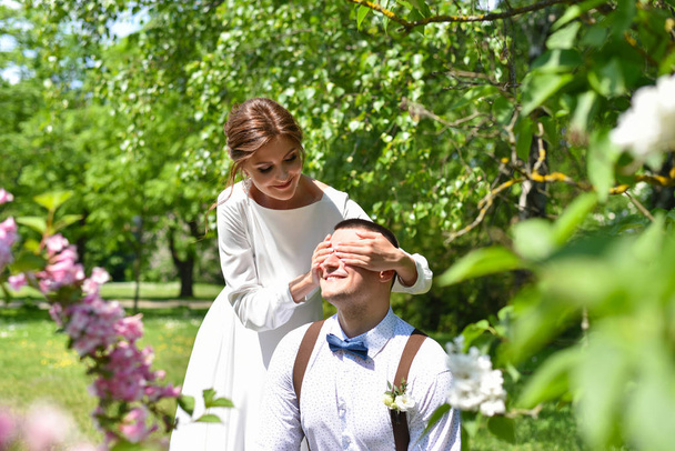 Nevěsta a ženich v kytice chodí v zeleném parku - Fotografie, Obrázek