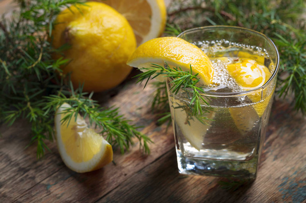 Gin, tonic en citroen op een oude houten tafel.  - Foto, afbeelding