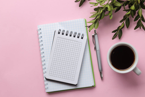 több notebook egy csésze kávét és virágot egy élénk rózsaszín háttér. felülnézetben. Office-eszközök - Fotó, kép