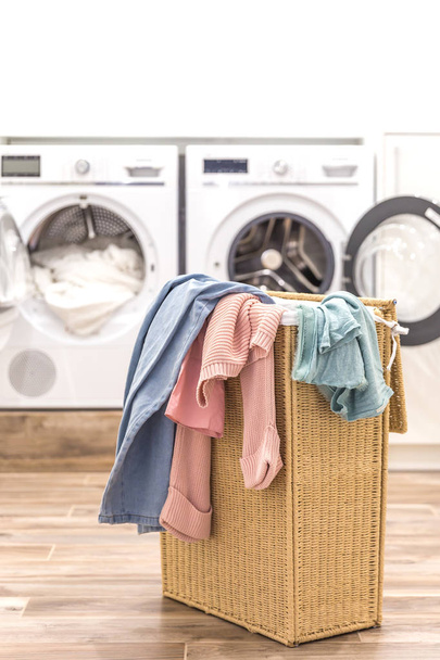 Lavanderia con cesto e lavatrici e asciugatrici sullo sfondo
 - Foto, immagini