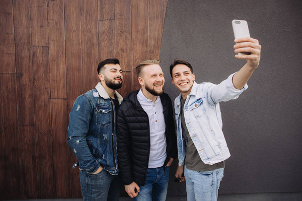 amis heureux prendre un selfie à côté du mur
  - Photo, image