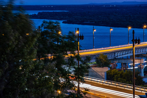 Γέφυρα πάνω από τον ποταμό Αμούρ στο Χαμπάροφσκ της Ρωσίας. Νυχτερινή φωτογράφιση. - Φωτογραφία, εικόνα