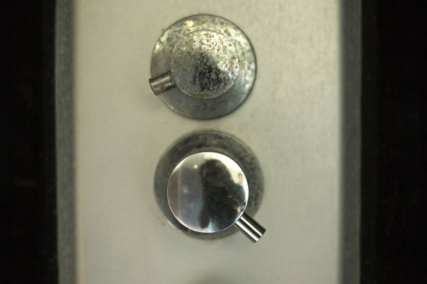 παλιά οξειδωμένα κουμπιά για ζεστό και κρύο νερό στο ντους - Φωτογραφία, εικόνα