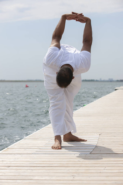 homem praticar ioga na praia ao pôr do sol
 - Foto, Imagem