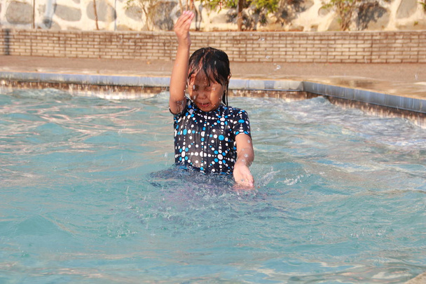 mała dziewczynka gra w wodzie w basenie uczucie wesoły, szczęśliwy i podnoszący na duchu - Zdjęcie, obraz