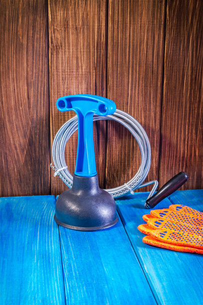Clean plastic plunger with blue handle and cable on vintage wooden background - Fotografie, Obrázek