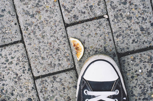 オレンジの皮が付いた歩道のスニーカー - 写真・画像