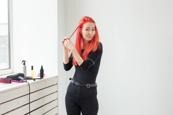Красивая рыжая девушка с длинными волосами, она плетет косу, в салоне красоты. Профессиональный уход за волосами
. - Фото, изображение