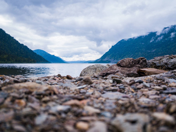 Kıyıda gri-kahverengi renk yuvarlak taşlar üzerinde yakın çekim - Fotoğraf, Görsel